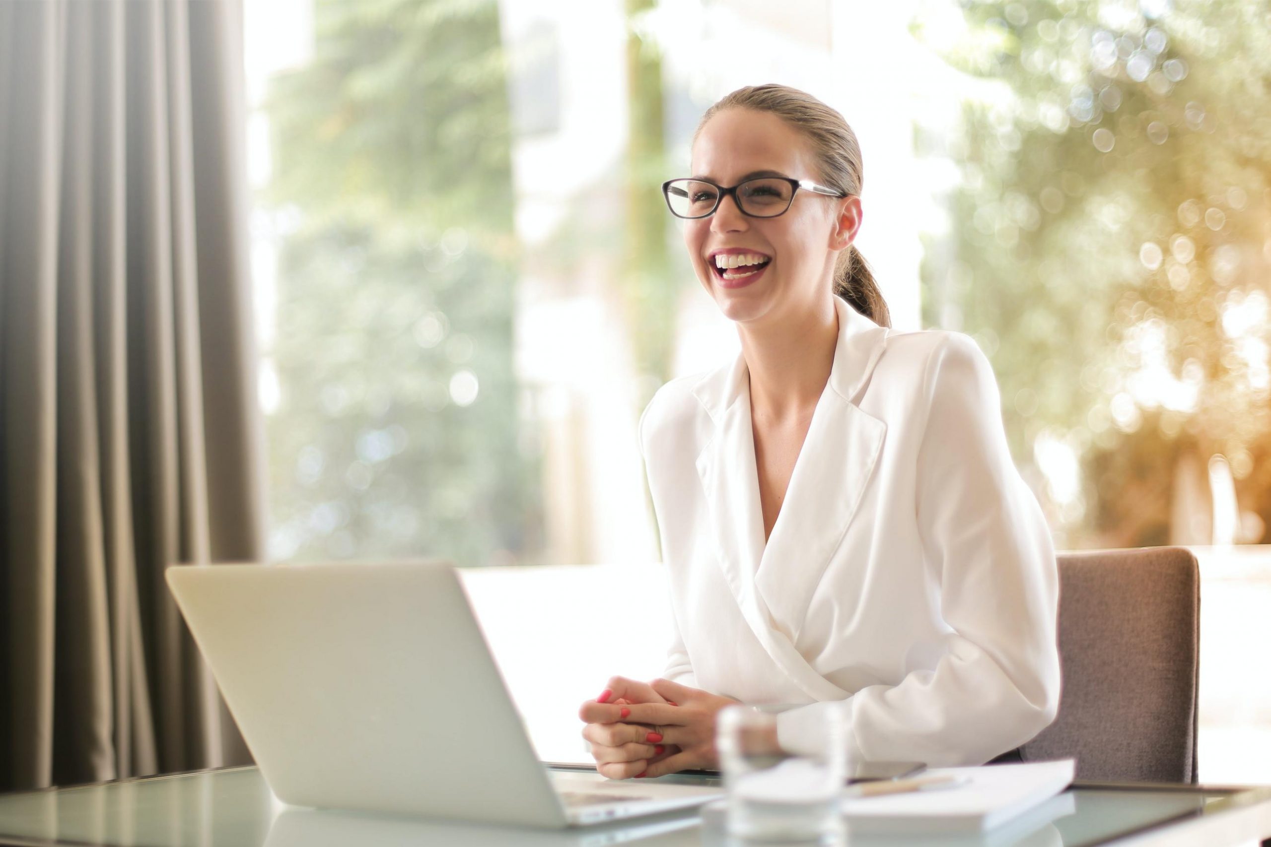 personal loan decision woman smiling beside laptop
