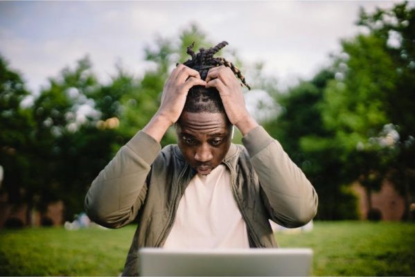 taking out a loan image of frustrated man looking at laptop