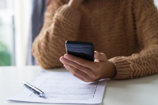 cosigner personal loans woman with cellphone and budget