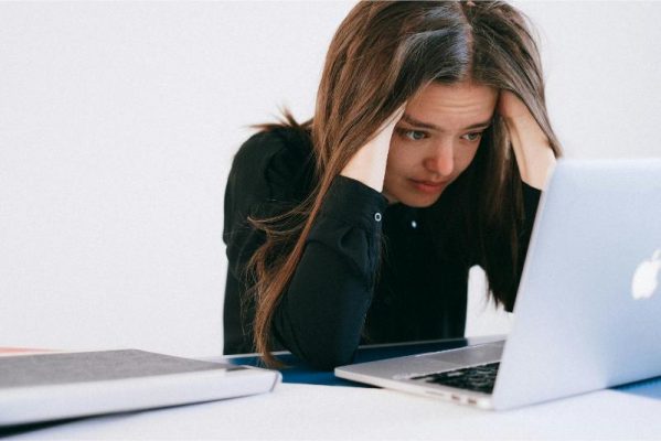 summer spending image of woman stressed looking at laptop