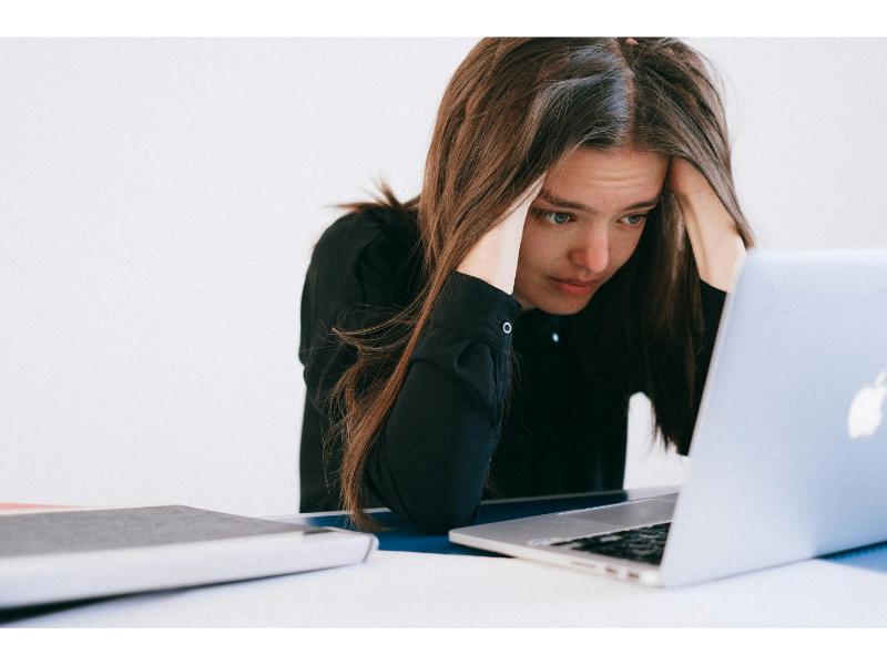 summer spending image of woman stressed looking at laptop